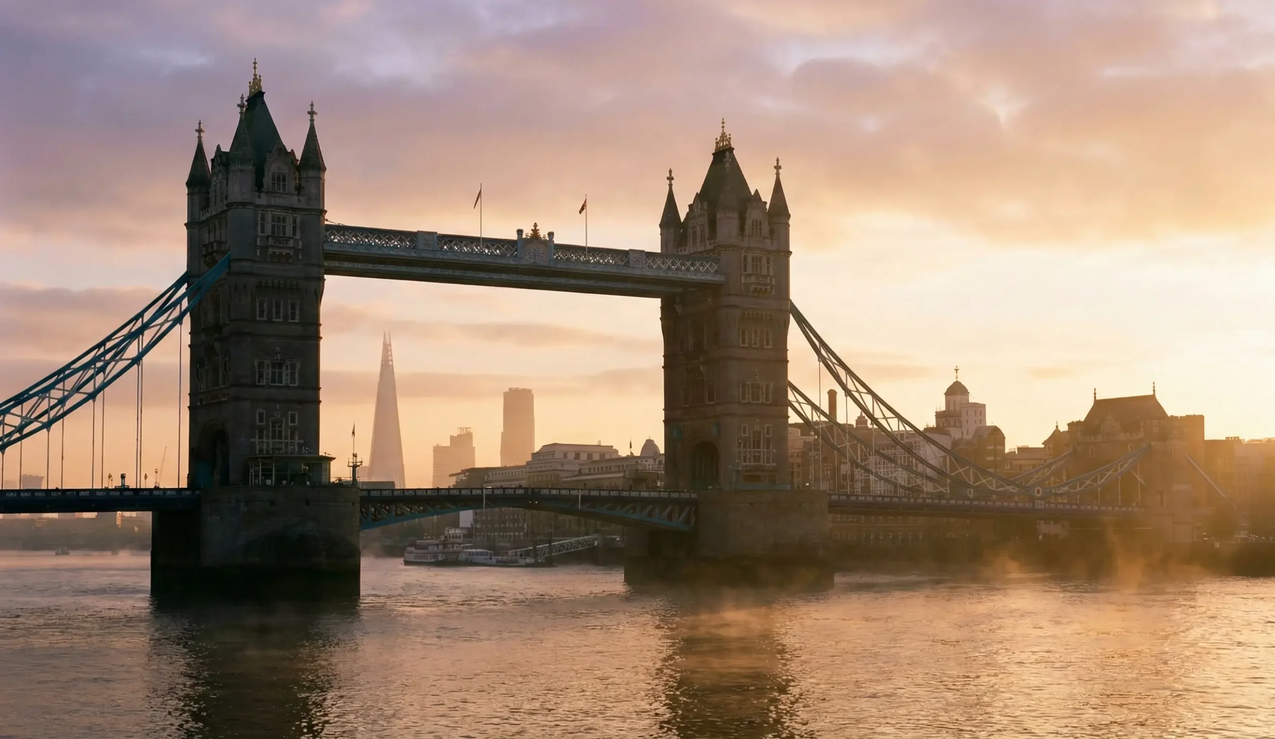 Tower Bridge i London i kvällsljus med Themsen i förgrunden.